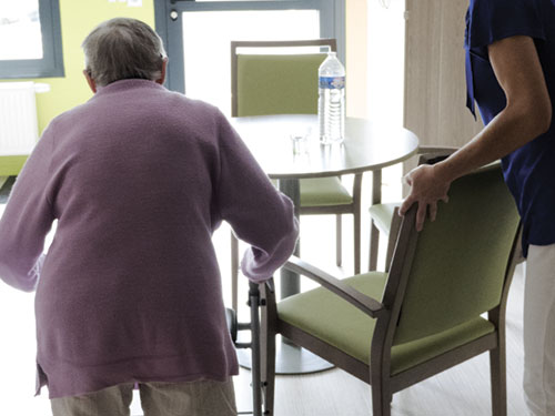 Photo d'un professionnel aidant une personne âgée en Résidence Escalys